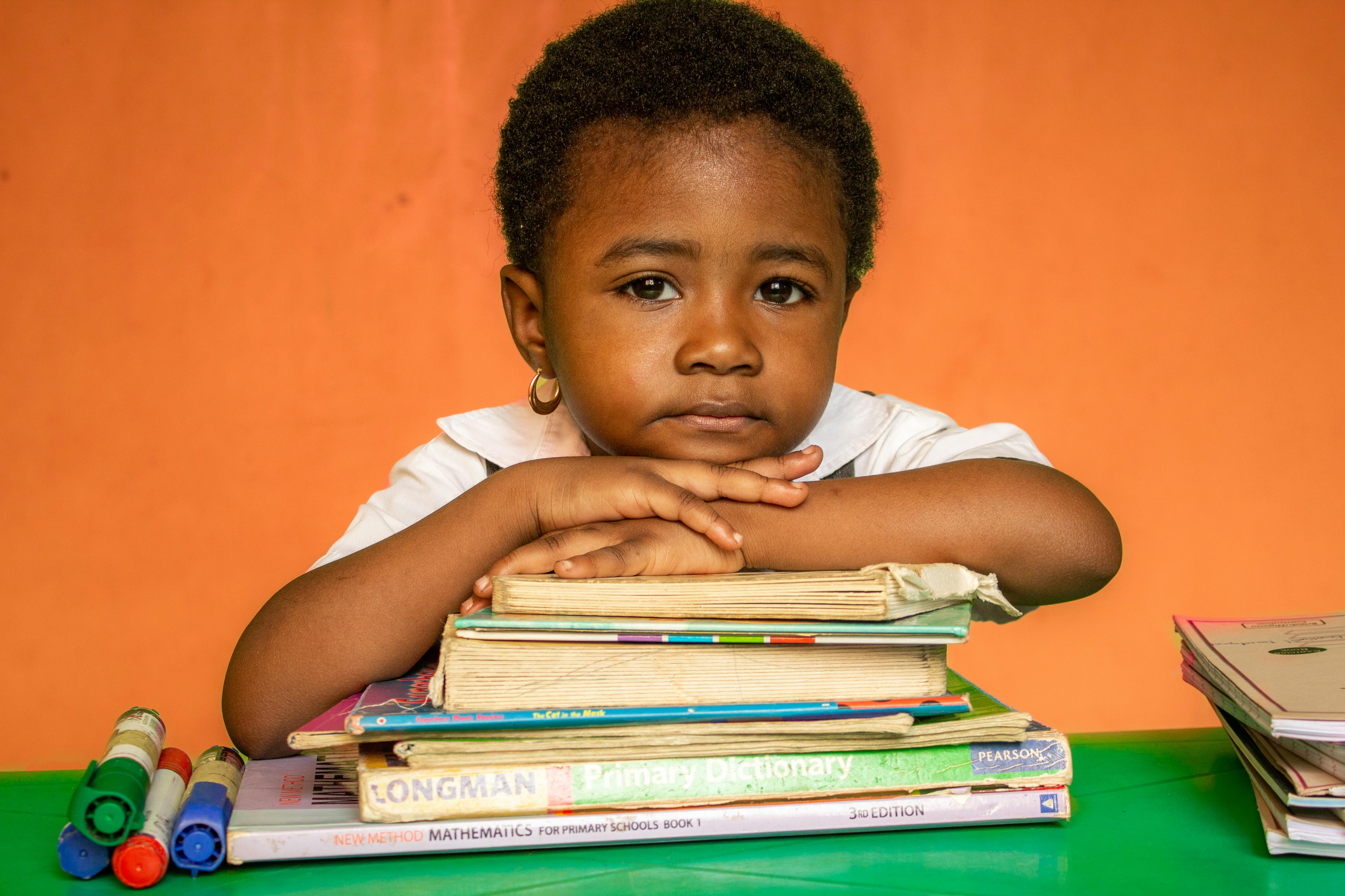 Student leaning on a stack of books